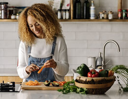 A woman peeling a carrot.