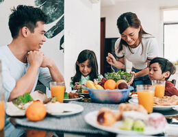 A family of four eating a meal together.